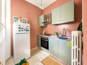 a small kitchen with pink walls and a white refrigerator at Interi Appartamenti in Centro - Holiday & Wi-Fi Ultra in Campobasso