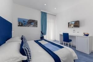 a bedroom with a bed and a desk and a chair at Hotel Metropole in Sorrento +162 photos