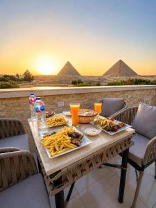 a table with food on it with a view of the pyramids at Cacillion Pyramids View in Cairo