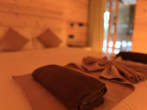 a towel on a bed with a bow on it at Wood Chalets Ella in Ella +74 photos