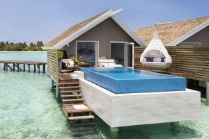 a house on the water with a swimming pool at LUX* South Ari Atoll Resort & Villas in Maamigili
