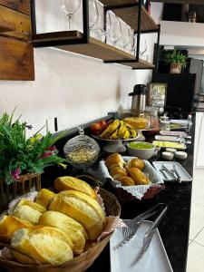 a table with baskets of bread and bowls of fruit at Hotel Cidade Imperial in Petrópolis