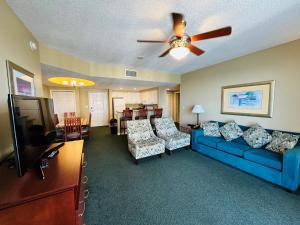 a living room with a blue couch and a tv at Ocean Walk Resort in Daytona Beach