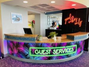 a lobby with a reception counter with neon signs at Ocean Walk Resort in Daytona Beach +48 photos