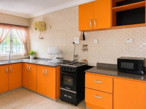 a kitchen with orange cabinets and a stove top oven at Tee's Place in Coker