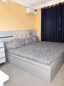 a bed in a room with a black curtain at Tee's Place in Coker