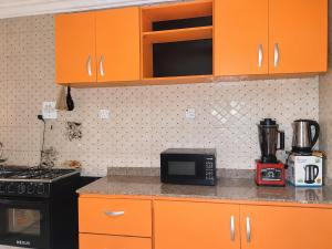 a kitchen with orange cabinets and a counter top at Tee's Place in Coker +9 photos