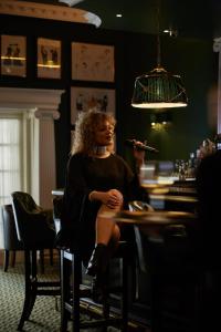 a woman sitting in a chair under a lamp at The Chesterfield Mayfair in London