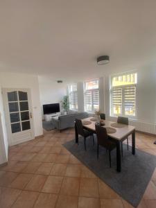 a living room with a table and chairs and a couch at Familly Jean Bart-Centre-ville in Dunkerque