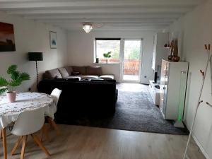 a living room with a couch and a table at Heide Nest Soltau in Soltau +4 photos
