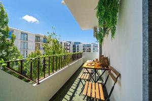 a balcony with a table and a bench on it at Stylish & Sleek Flat near the Beach by HostWise in Armação de Pêra