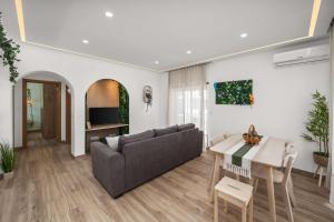 a living room with a couch and a table at Stylish & Sleek Flat near the Beach by HostWise in Armação de Pêra