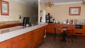 a kitchen with a bar with a table and chairs at Magnuson Hotel Fowlerville in Fowlerville