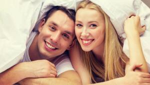 a man and a woman laying in bed at Magnuson Hotel Fowlerville in Fowlerville +3 photos