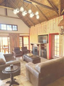a living room with a couch and a television at Mabalingwe Mistykie Lodge in Warmbaths