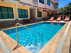 a swimming pool in a house with chairs in it at Hotel Flamingo in Puerto Ayora