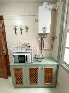 a kitchen with a counter with a microwave on it at Piso en el Corazón de Ferrol in Ferrol +18 photos