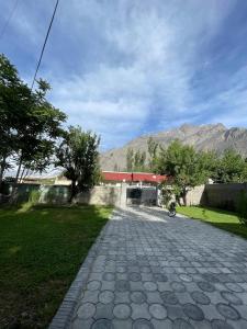a brick road with a building with a mountain in the background at The Northleaf Cottage in Skardu