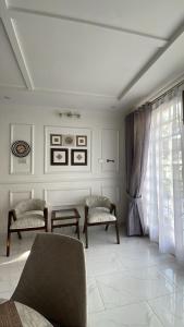 a living room with two chairs and a window at The Northleaf Cottage in Skardu
