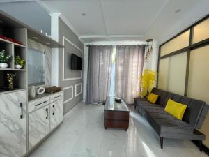 a living room with a black couch and yellow pillows at The Northleaf Cottage in Skardu