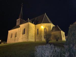 a church lit up at night with a light at Brin d'Air Lodge in Montcornet