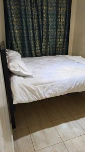 a bed in a room with a black curtain at Serenity Breeze in Ongata Rongai 