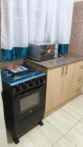 a kitchen with a stove and a microwave on a counter at Serenity Breeze in Ongata Rongai 