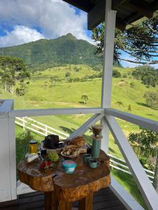 a table on a porch with a view of a field at Cabana Sítio Costãozinho in Bom Retiro