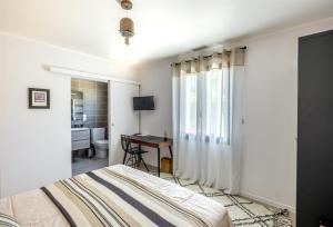 a bedroom with a bed and a desk and a window at Villa Géna in Saint-Médard-dʼEyrans +36 photos
