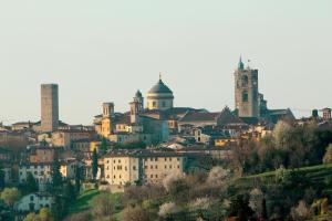 a group of buildings on a hill with two towers at Bergamo Hideout in Bergamo