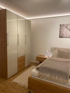 a bedroom with a bed and a dresser and cabinets at Ferienwohnung Servus in Traunstein