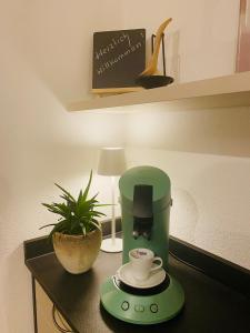 a green coffee maker and a cup on a counter at Ferienwohnung Servus in Traunstein