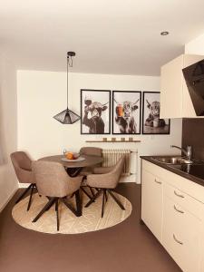 a kitchen with a table and some pictures on the wall at Ferienwohnung Servus in Traunstein