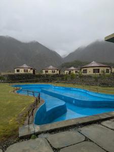 a pool with blue water in front of some houses at Sukoon Resorts Skardu in Skardu