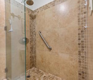 a bathroom with a shower with a glass door at Plantation Hale Suites in Kapaa