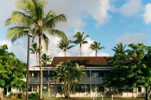 a building with palm trees in front of it at Plantation Hale Suites in Kapaa
