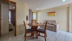 a living room with a table and chairs and a couch at Paradise Flat in Natal +44 photos