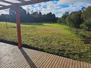 a porch with a view of a field of grass at Tiny House en parcela de Puerto Varas in Puerto Varas