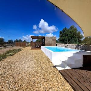 a swimming pool with a pavilion next to a house at Luz Retreat in Luz de Tavira