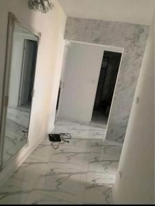 a room with a tile floor and a mirror at Alfa Apartment in Dej