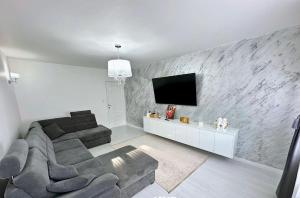 a living room with a couch and a flat screen tv at Alfa Apartment in Dej