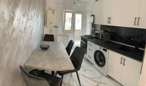 a kitchen with a table and chairs in a kitchen at Alfa Apartment in Dej