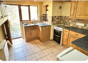 a kitchen with a sink and a stove top oven at Kingfisher Cottage Wales in Llanidloes