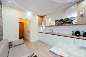 a living room with a couch and a kitchen at Central Apartment Facing the Cathedral in Chişinău