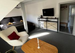 a room with a bed and a chair and a table at Fewo Charlotte in Weimar