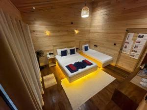 a bedroom with two beds in a wooden room at Wood Chalets Ella in Ella
