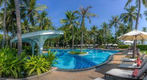 a pool at a resort with palm trees at Centara Grand Beach Resort Hua Hin in Hua Hin