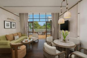 a living room with a couch and a table and chairs at Centara Grand Beach Resort Hua Hin in Hua Hin