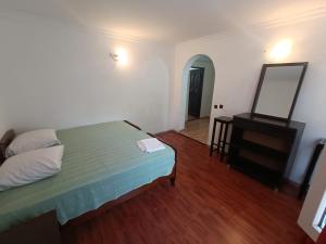 a bedroom with a bed and a dresser and a mirror at Happy house in Kobuleti