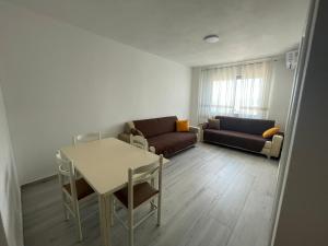 a living room with a table and a couch at Golem Apartments in Golem
